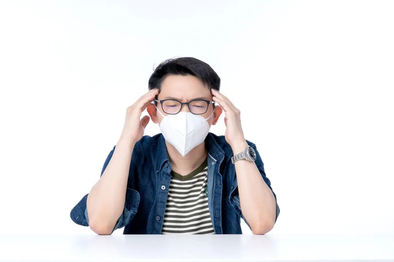 Primer plano de un joven empresario asiático que lleva una mascarilla antipolución y hace un gesto que expresa malestar y mala salud debido al clima y al problema ambiental del aire urbano con PM2.5.