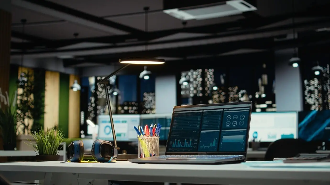 Oficina moderna y lujosa con un escritorio vacío y un portátil que muestra informes importantes con datos importantes.